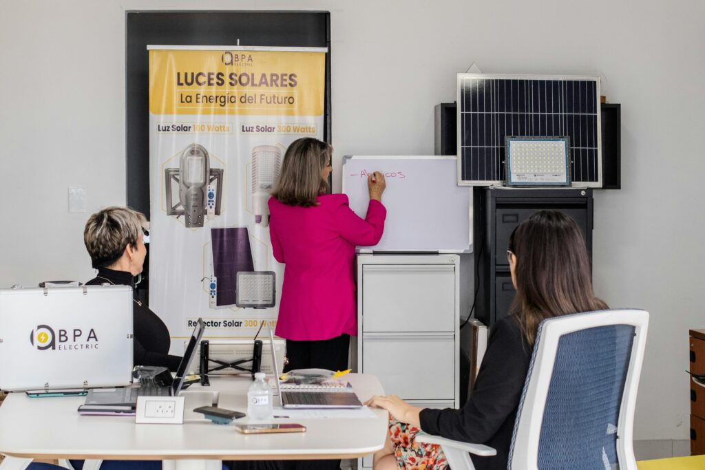 A team engaged in brainstorming solar energy solutions with panels and a whiteboard in an office.